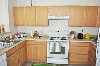 A kitchen with white appliances and wooden cabinets

Description generated with very high confidence